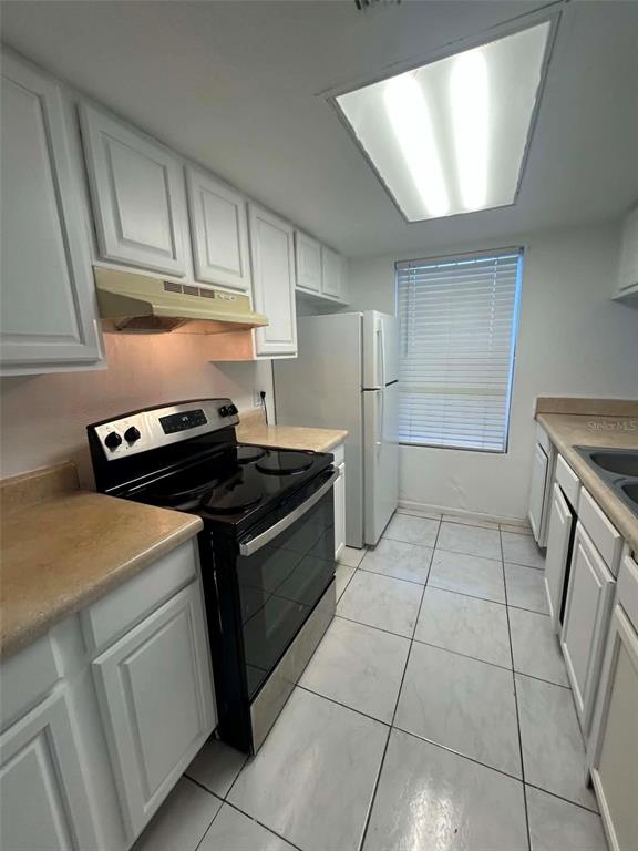 4031 Henley Road, Unit 1706 Orlando, FL 32839 - Photo 7 of 41 a kitchen with a stove cabinets and a refrigerator