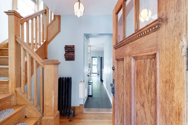 a view of a hallway with wooden floor and staircase