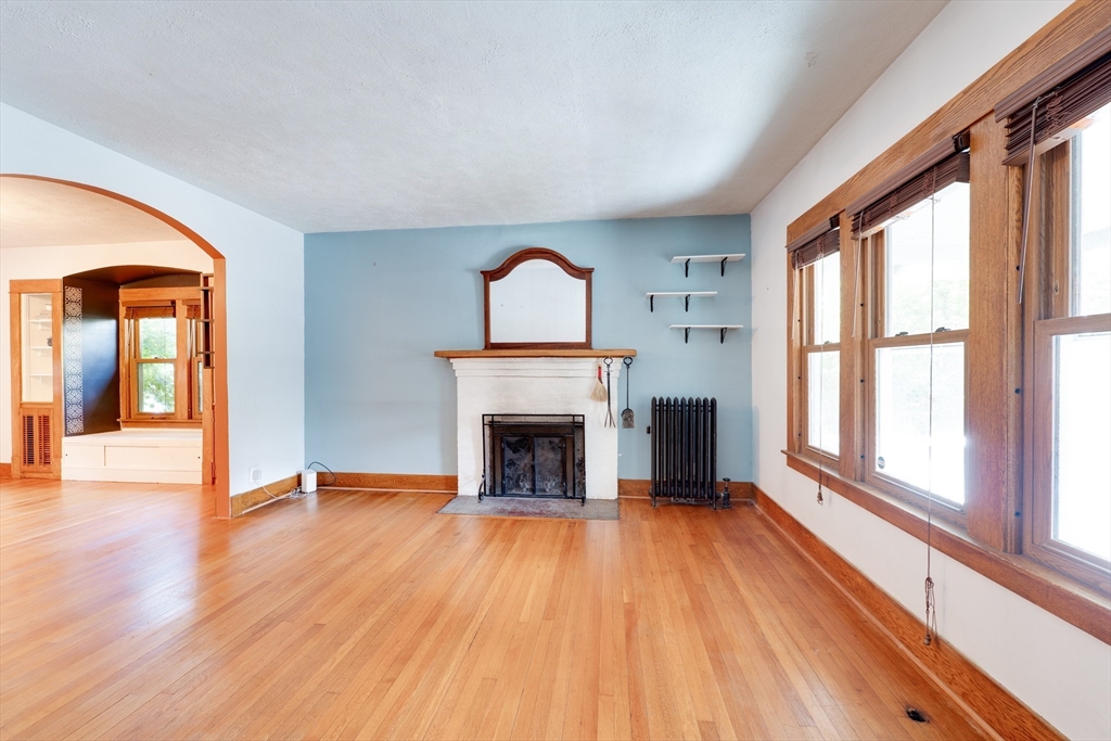 60 Blake Street Springfield, MA 01108 - Photo 3 of 30 a view of an empty room with wooden floor fireplace and a window