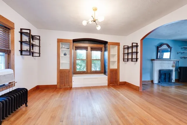 a view of empty room with wooden floor and fireplace