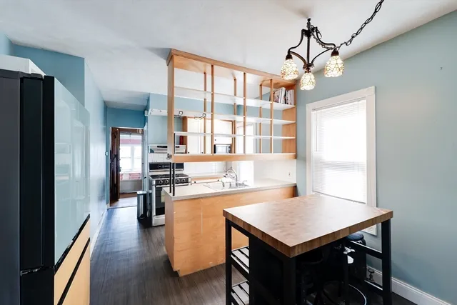 a kitchen with a table chairs and refrigerator