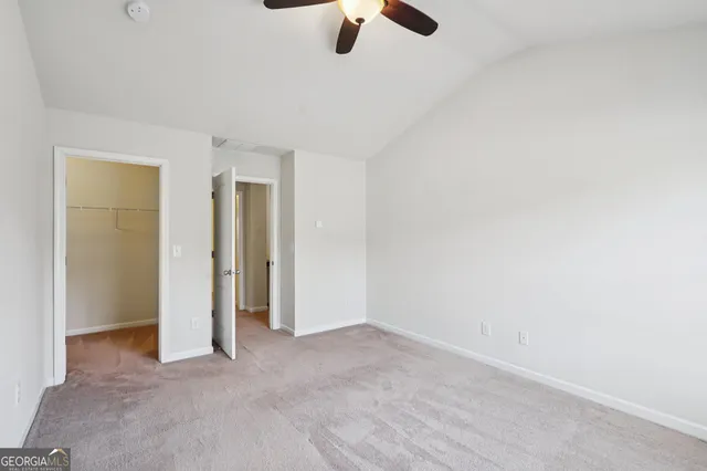 an empty room with ceiling fan and window