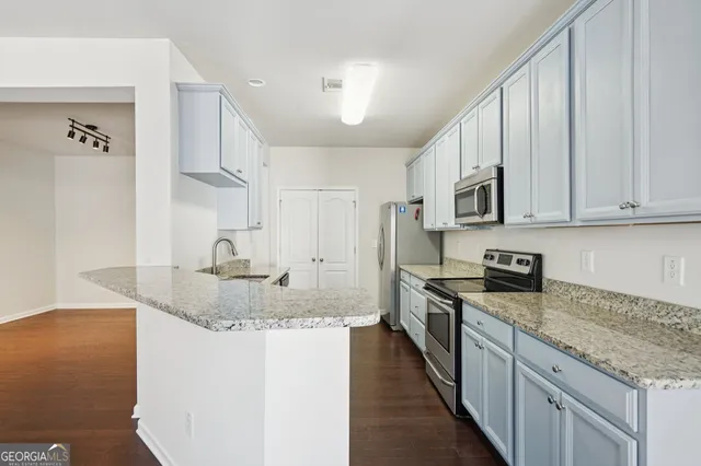 a kitchen with stainless steel appliances granite countertop a sink stove and refrigerator