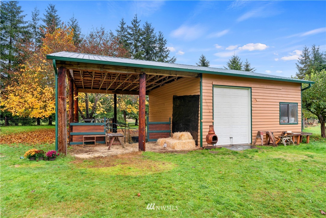 17221 Dodd Lane Southwest Rochester, WA 98579 - Photo 25 of 37 a view of a backyard with table and chairs and a large tree