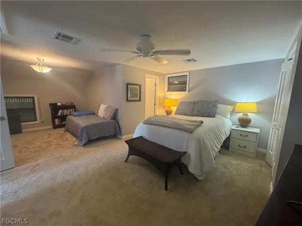a spacious bedroom with a bed and a chandelier