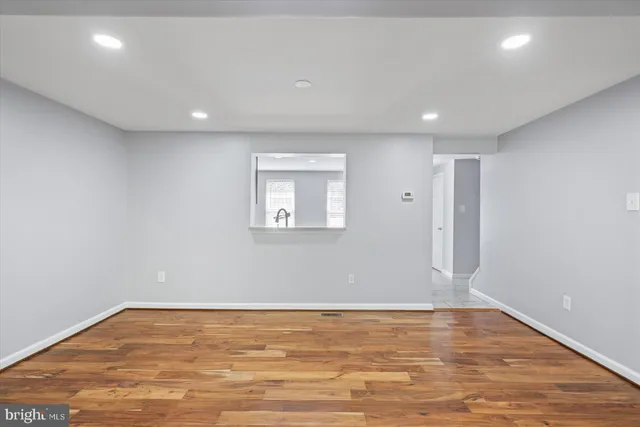 a view of empty room with wooden floor