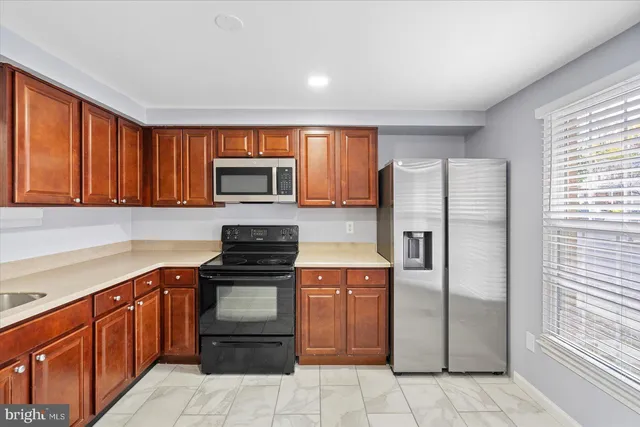 a kitchen with stainless steel appliances granite countertop a refrigerator stove and sink