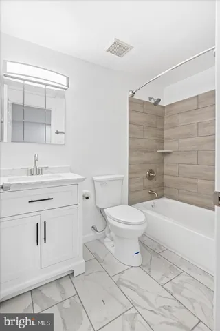 a bathroom with a sink a toilet and bathtub