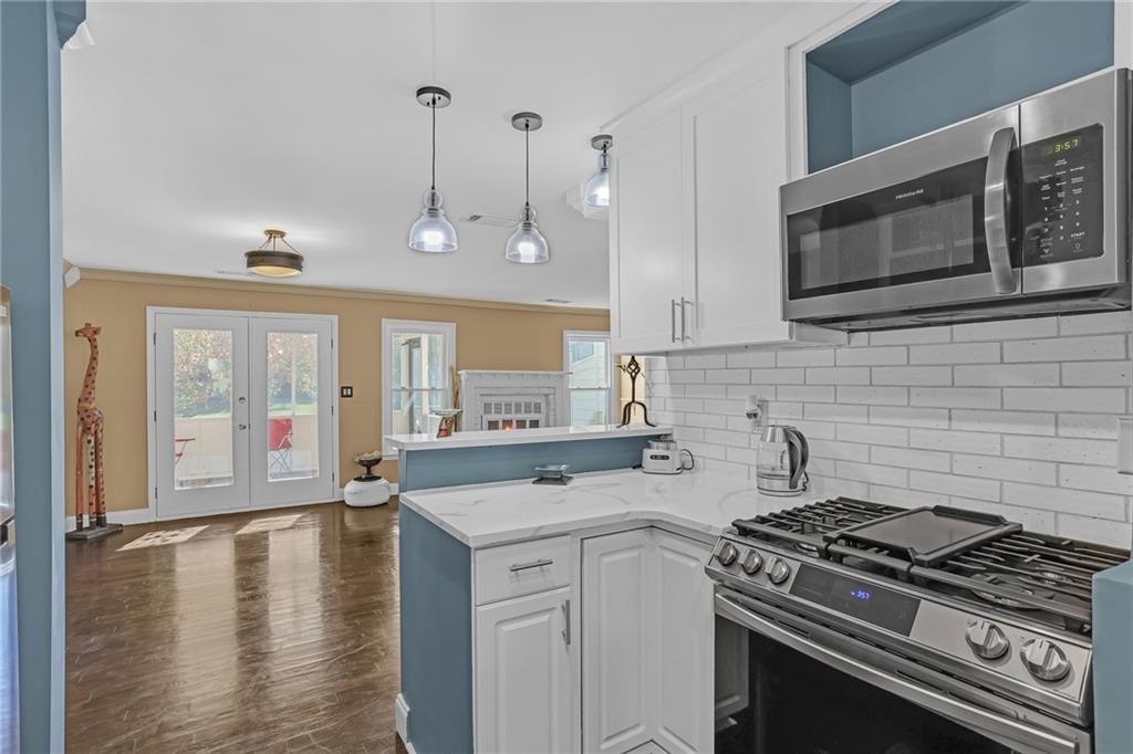 6315 Windsor Trace Drive Peachtree Corners, GA 30092 - Photo 11 of 26 a kitchen with a stove a sink and wooden floor
