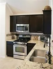 a kitchen with granite countertop a stove and a microwave