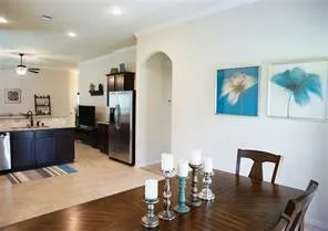 a kitchen with stainless steel appliances granite countertop a refrigerator a stove a dining table and chairs with wooden floor