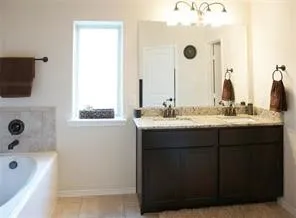 a bathroom with a tub sink and mirror