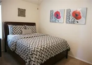 a bedroom with a bed and painting on the wall