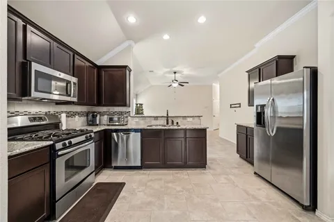 a kitchen with stainless steel appliances granite countertop a sink stove and refrigerator