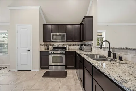 a kitchen with stainless steel appliances kitchen island granite countertop a refrigerator and a sink