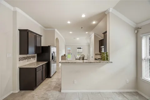 a view of a kitchen with kitchen island granite countertop a refrigerator oven a sink and dishwasher