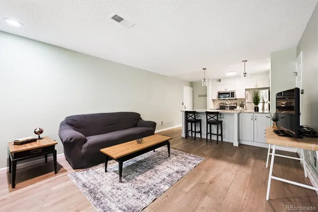 a living room with furniture and a wooden floor