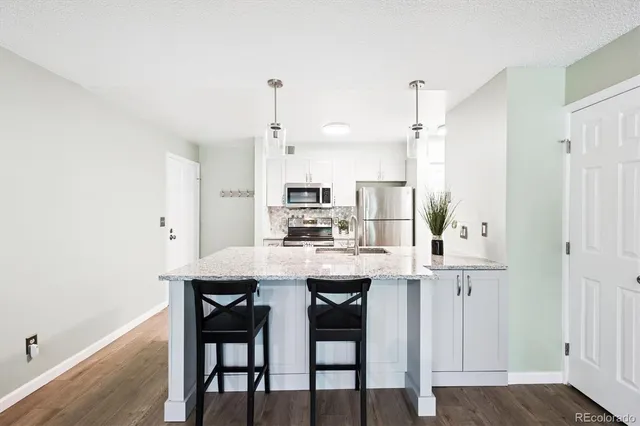 a kitchen with stainless steel appliances kitchen island a table and chairs in it