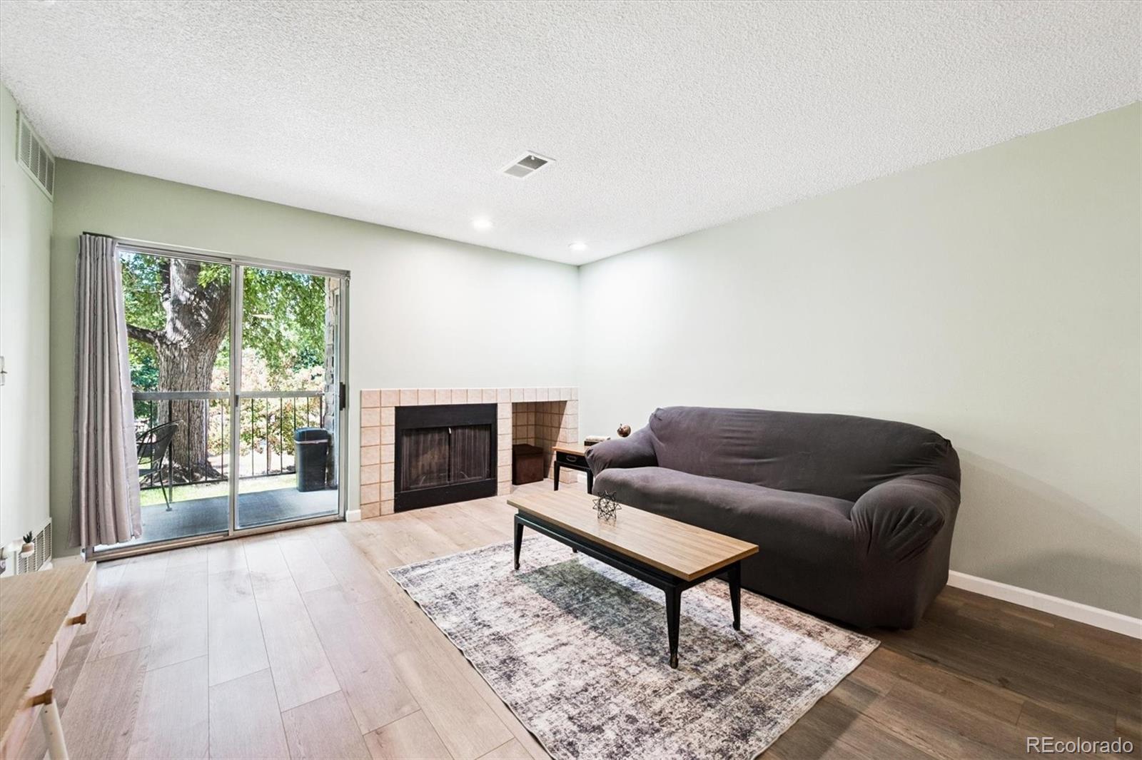 2575 South Syracuse Way, Unit L103 Denver, CO 80231 - Photo 7 of 21 a living room with furniture and a fireplace