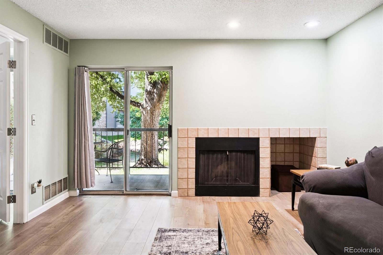 2575 South Syracuse Way, Unit L103 Denver, CO 80231 - Photo 8 of 21 a living room with furniture and a fireplace