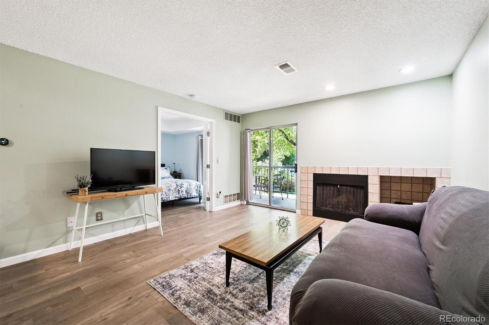 2575 South Syracuse Way, Unit L103 Denver, CO 80231 - Photo 9 of 21 a living room with furniture and a flat screen tv