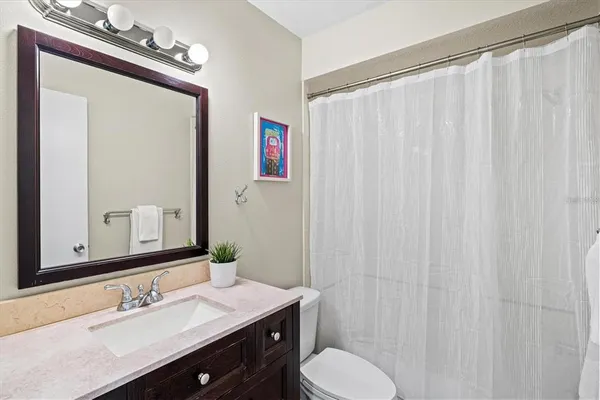 a bathroom with a sink vanity mirror and toilet