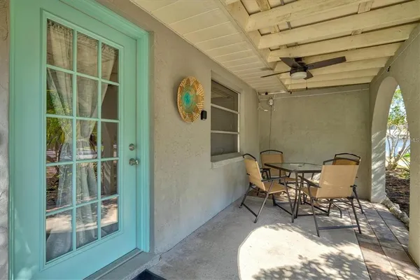 a patio with table and chairs and potted plants