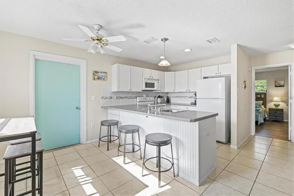 a kitchen with kitchen island granite countertop a sink cabinets and refrigerator