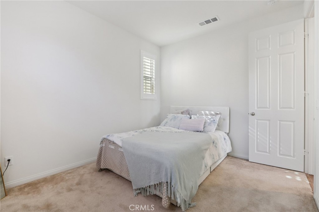 7656 Channel View Street Chino, CA 91708 - Photo 20 of 40 a bedroom with a bed and a window