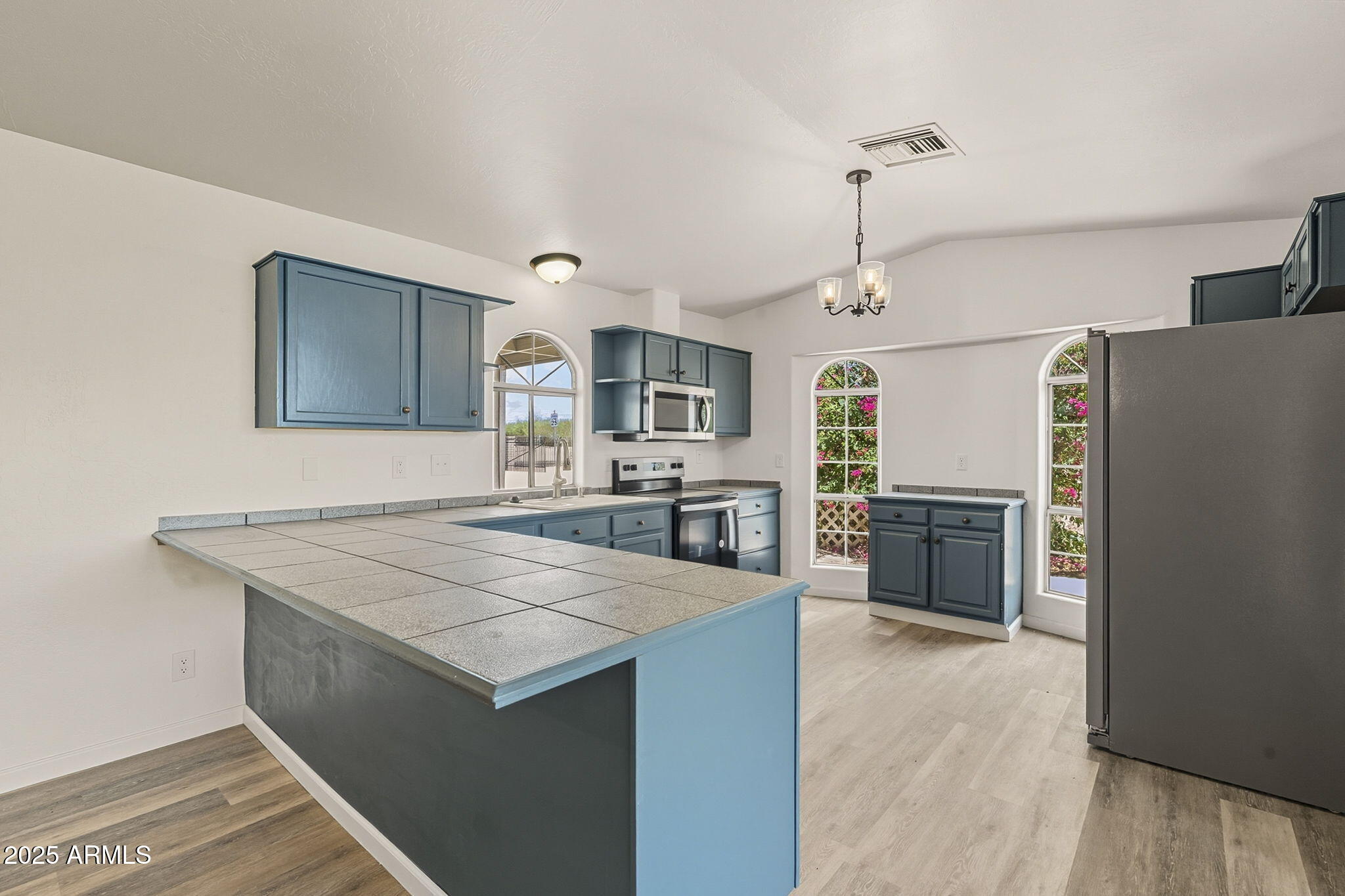 481 West Foothill Street Apache Junction, AZ 85120 - Photo 10 of 50 a kitchen with a refrigerator a sink dishwasher with a oven and chairs with wooden floor