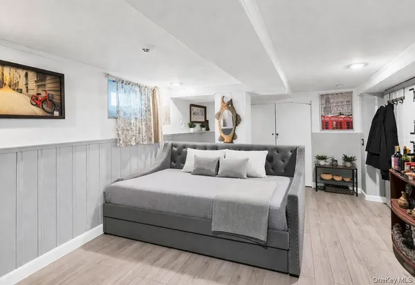 a bedroom with a large bed and a flat tv screen on dresser