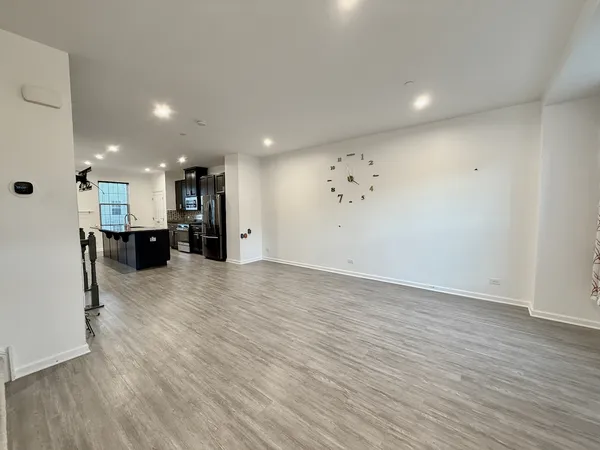 a view of a big room with wooden floor and windows