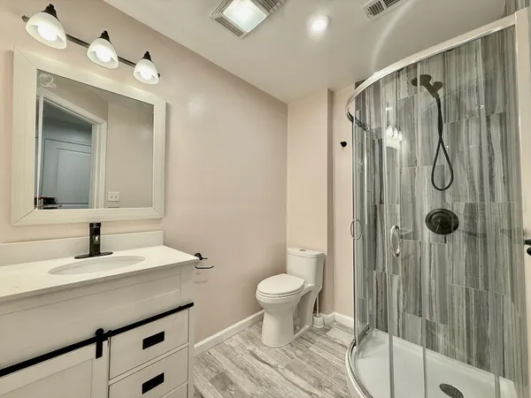 a bathroom with a sink a toilet and shower