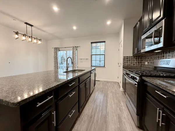 a kitchen with granite countertop stainless steel appliances and wooden cabinets