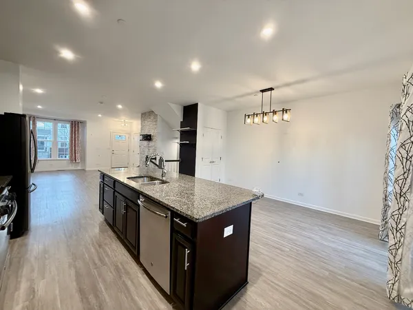 a kitchen with a stove and a wooden floor
