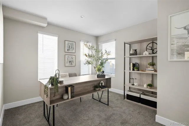 a view of a workspace with furniture and a window