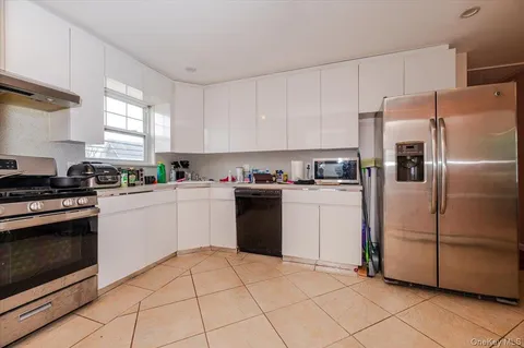 a kitchen with white cabinets and white appliances
