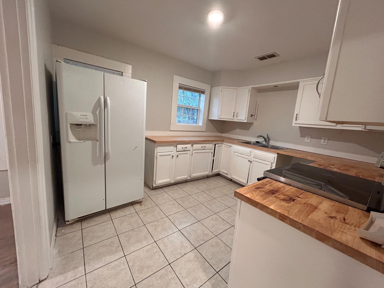 1925 26th Street Lubbock, TX 79411 - Photo 4 of 10 a kitchen with a refrigerator sink and cabinets
