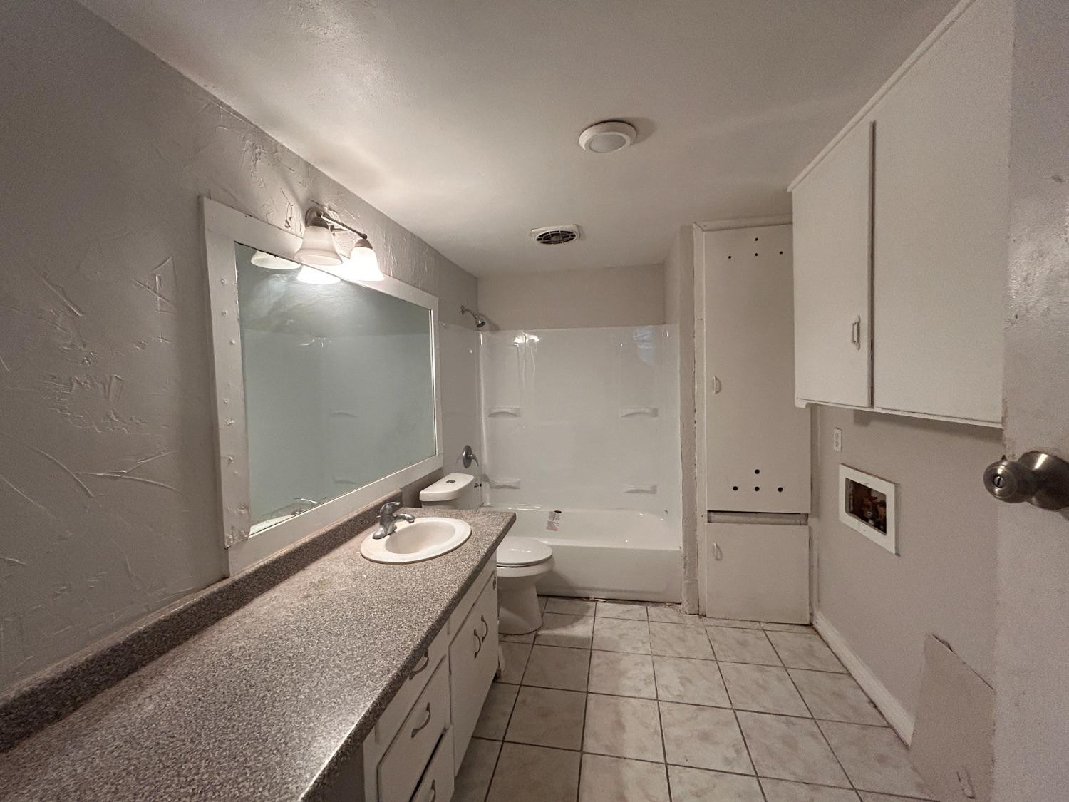 1925 26th Street Lubbock, TX 79411 - Photo 6 of 10 a bathroom with a granite countertop sink a toilet and shower