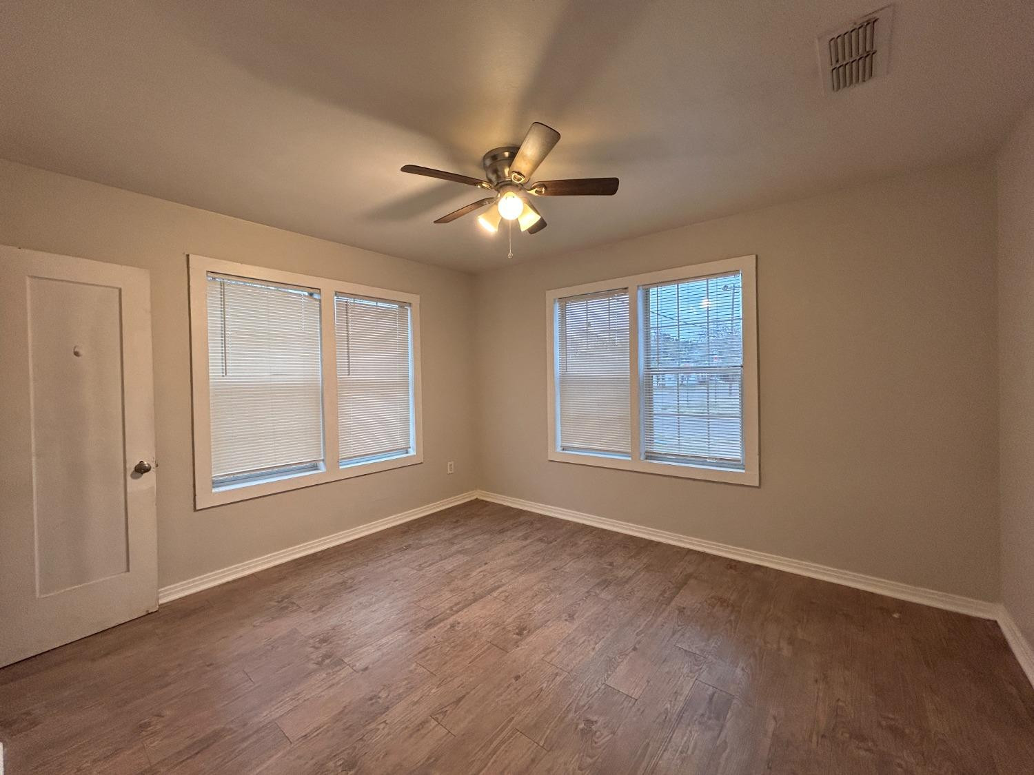 1925 26th Street Lubbock, TX 79411 - Photo 8 of 10 a view of an empty room with chandelier fan and a window