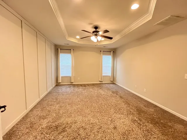 a view of an empty room and chandelier fan
