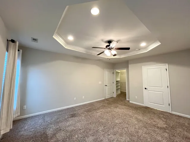 an empty room with closet and a ceiling fan