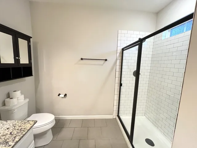 a bathroom with a granite countertop sink toilet and shower