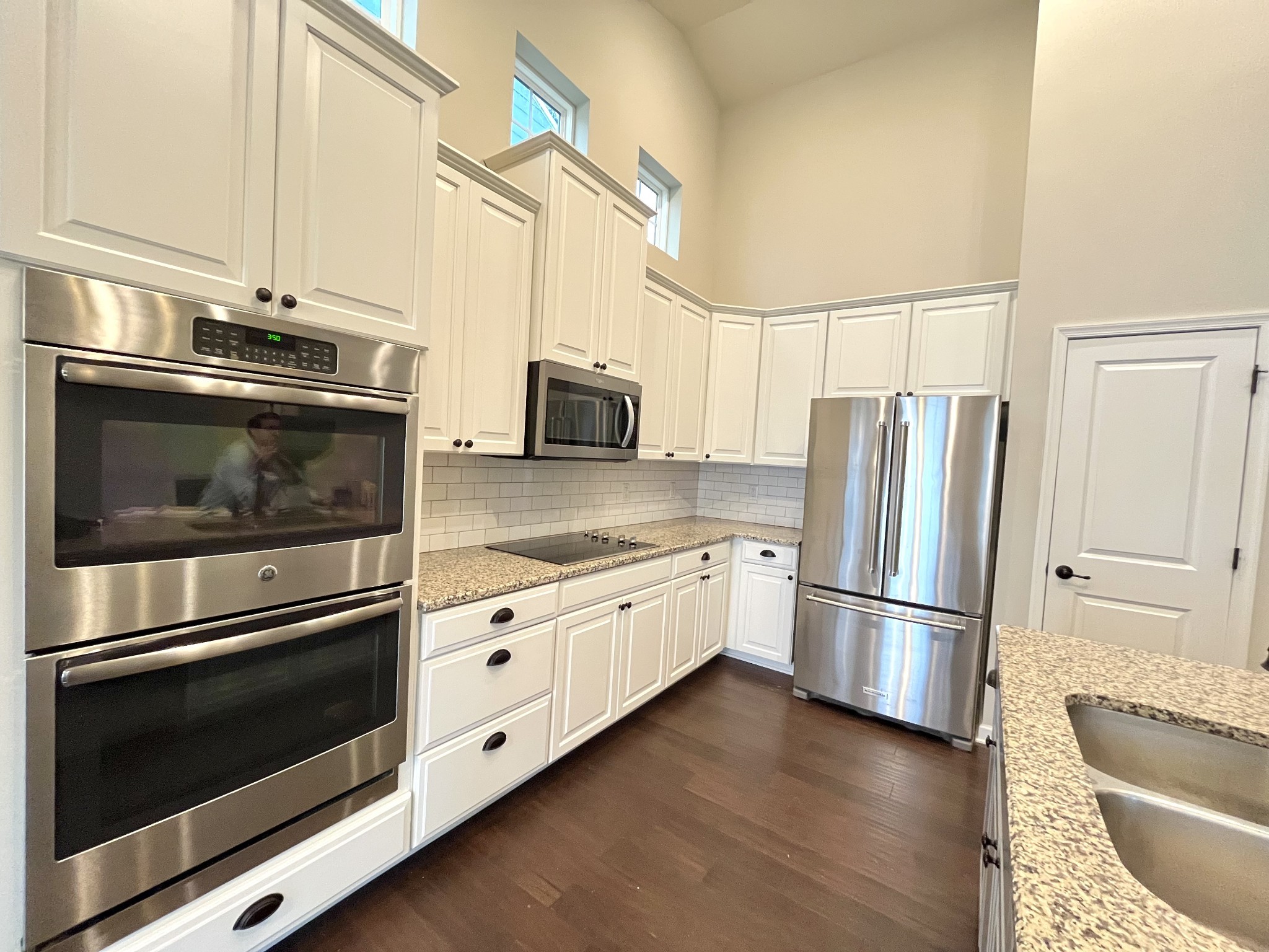2817 Bluestem Lane Murfreesboro, TN 37128 - Photo 26 of 33 a kitchen with granite countertop white cabinets stainless steel appliances and wooden floor
