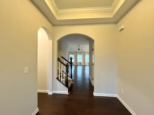 a view of a hallway with wooden floor and staircase