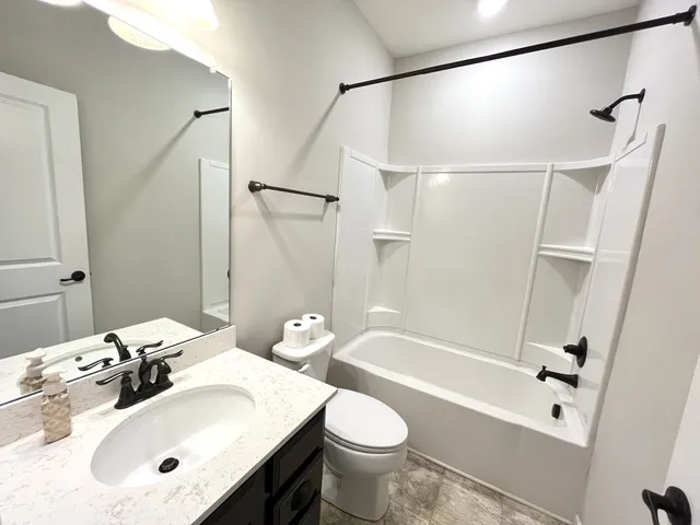 a bathroom with a sink mirror toilet and bathtub