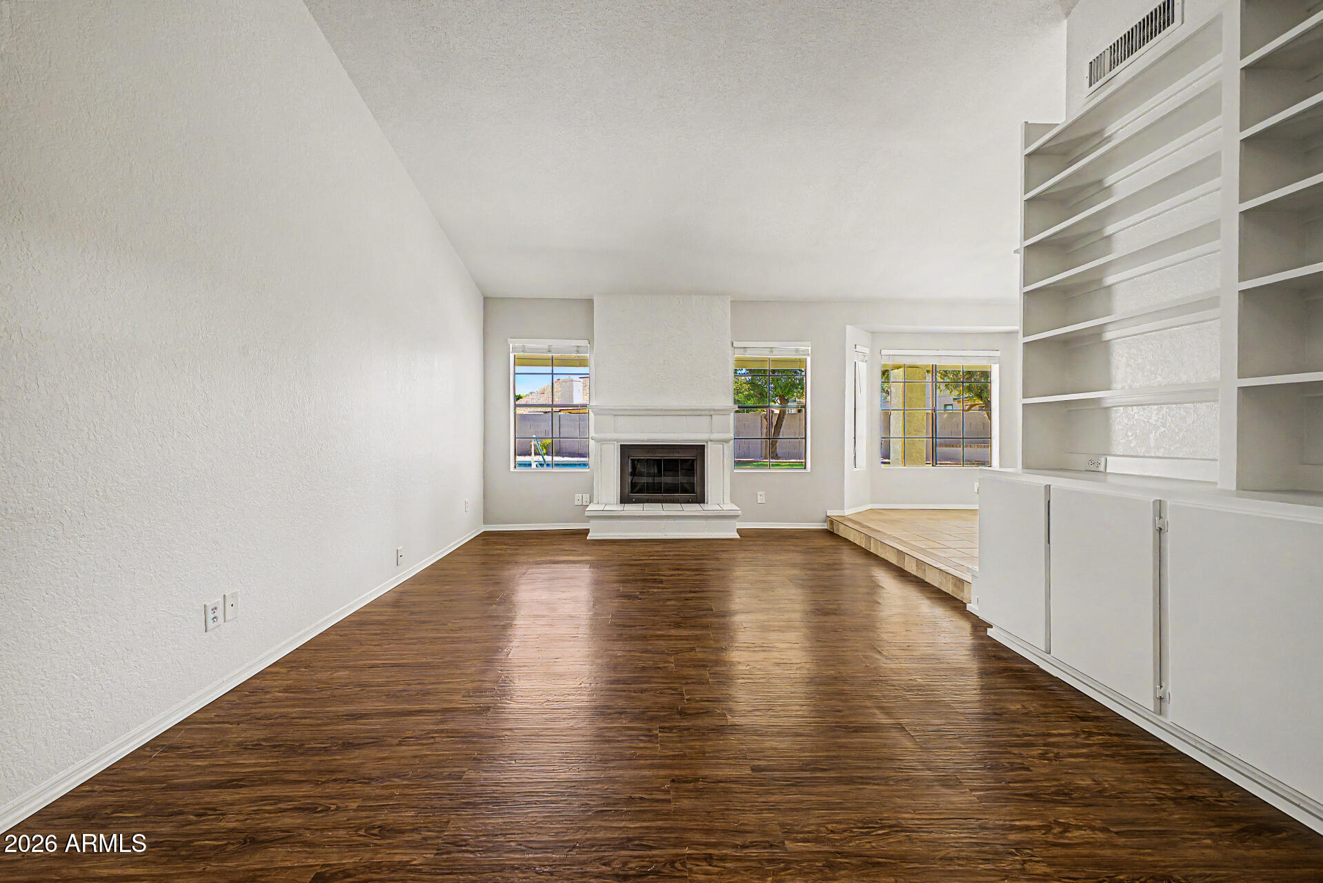 6725 West Utopia Road Glendale, AZ 85308 - Photo 8 of 27 a view of an empty room with a fireplace and a window