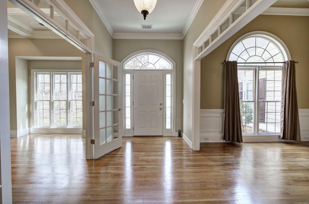 302 Waterfall Court Canton, GA 30115 - Photo 5 of 80 an empty room with wooden floor chandelier and glass door