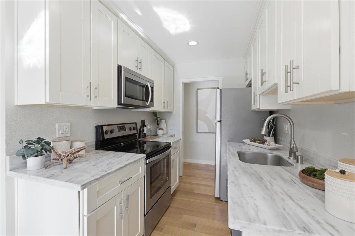 280 Easy Street, Unit 307 Mountain View, CA 94043 - Photo 14 of 30 a kitchen with stainless steel appliances granite countertop a sink stove refrigerator and cabinets