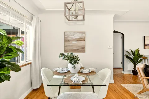 a dining room with furniture potted plants and wooden floor